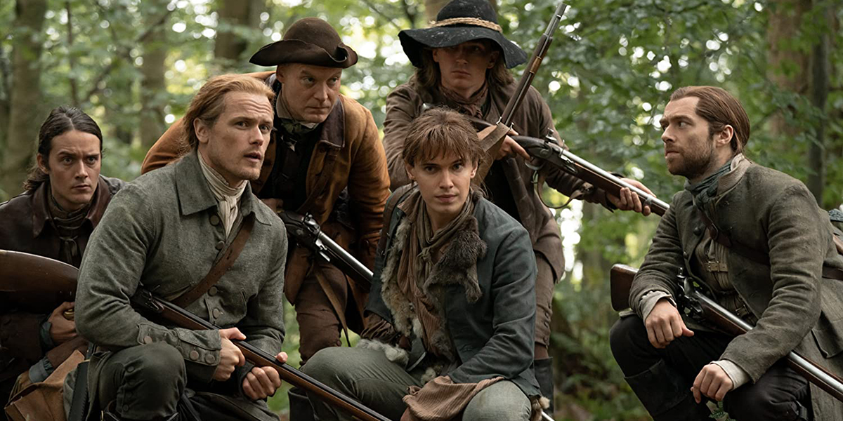 Jamie, Fergus, Roger Mac, Josiah the Hunter and others crouch as they plan their attack on a herd of bison in Outlander's "Monsters and Heroes"