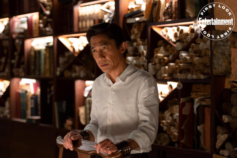 Wenwu standing on his own behind a bar in EW first look image.
