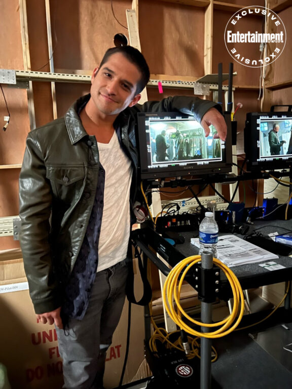 Actor Tyler Posey leaning on a computer screen behind the scenes of Teen Wolf The Movie