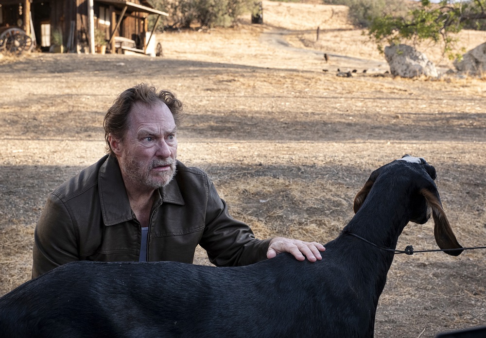 Monroe Fuches sits beside a goat in the countryside on Barry Season 3 Episode 1, "forgiving jeff."