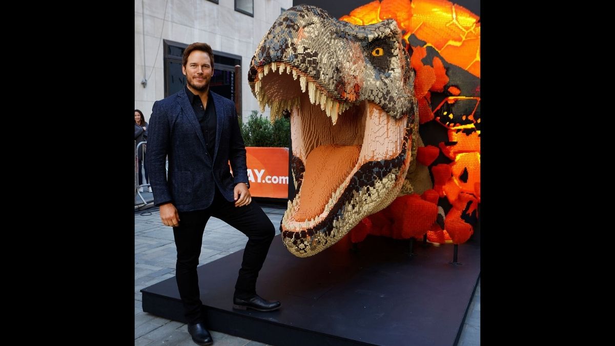 Chris Pratt posing with LEGO statue of T-Rex