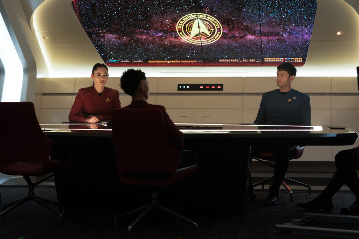 Christine Chong as La'an, Melissa Navia as Ortegas, and Ethan Peck as Spock in the Ready Room of the Enterprise.