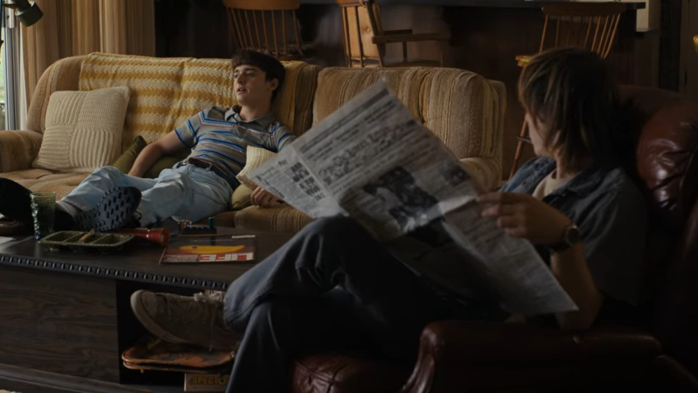 Will and Jonathan sitting in the living room watching TV and reading the newspaper.