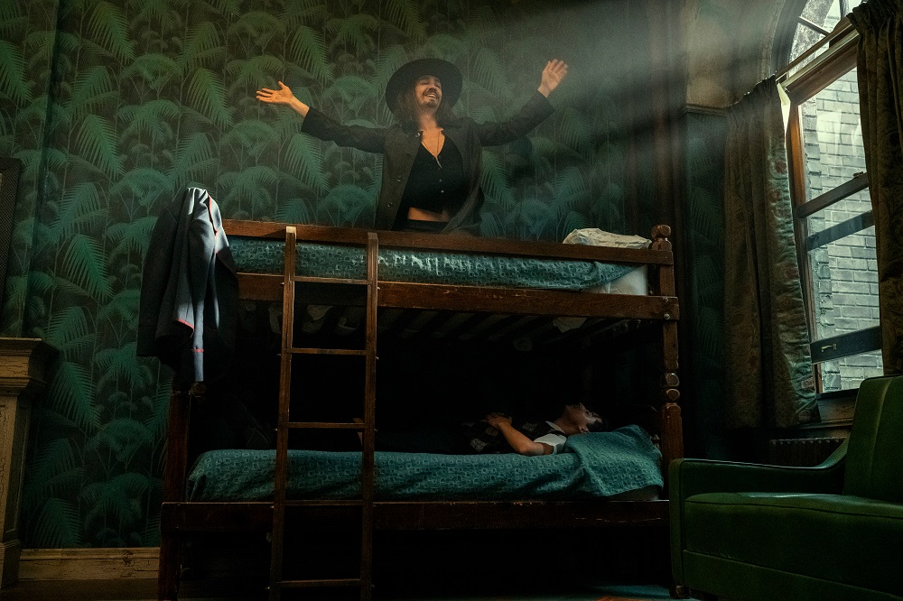 Klaus sitting on the top bunk of a bunkbed while Number Five lays in the lower bunk in The Umbrella Academy Season 3 Episode 1 "Meet the Family."