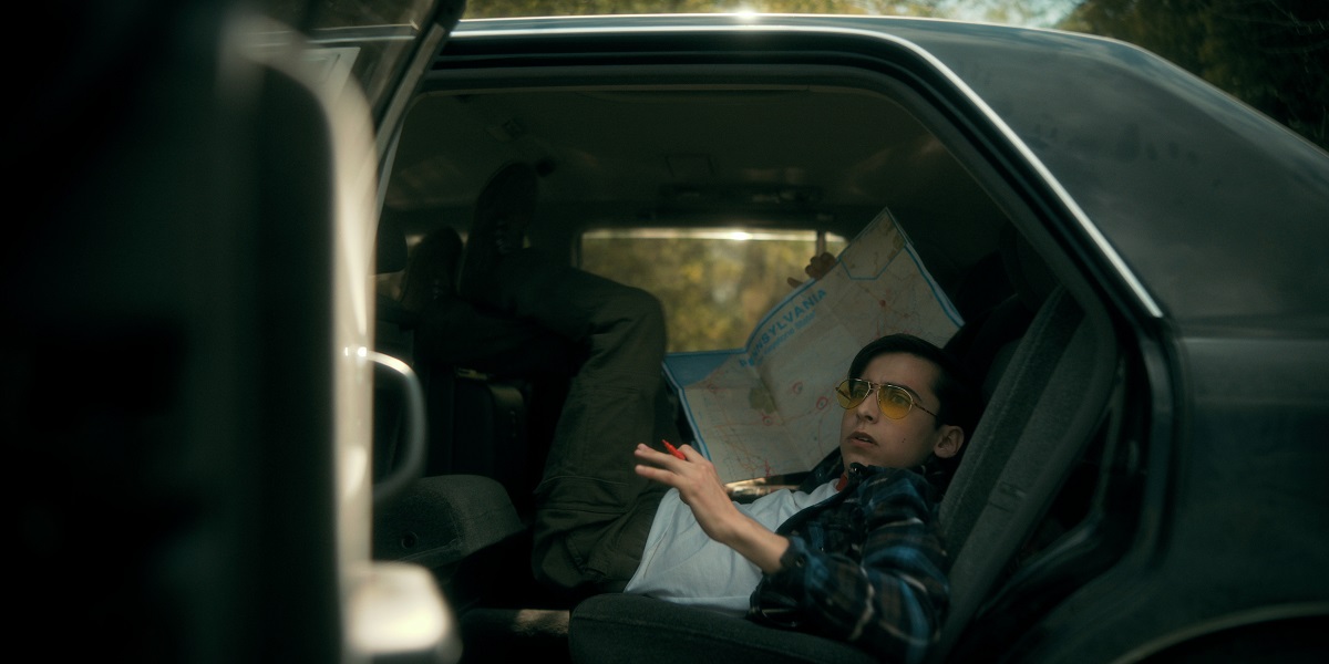 Number Five squeezed in the backseat of a car while looking startled in The Umbrella Academy Season 3 Episode 2 "World's Biggest Ball of Twine."
