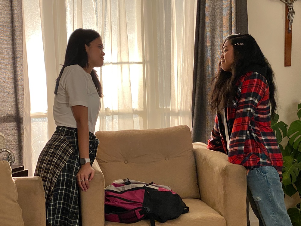 Gabby and Tala standing in the living room while having a conversation on Topline by Romeo Candido.
