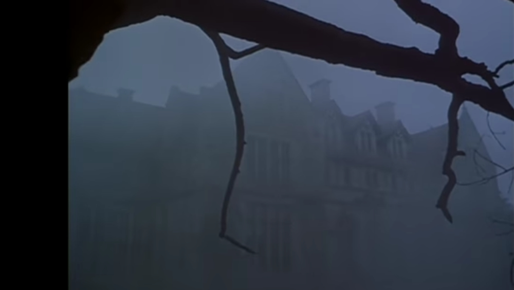 A large house appears through the thick fog