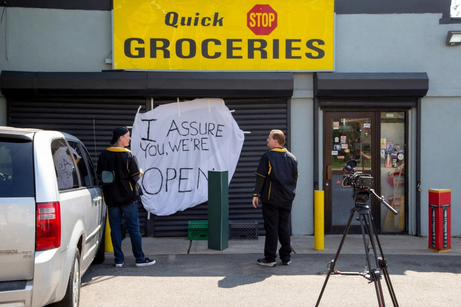 Randal and Dante standing in front of the Quick Stop looking at the "I assure you were're open" sign in Clerks III.