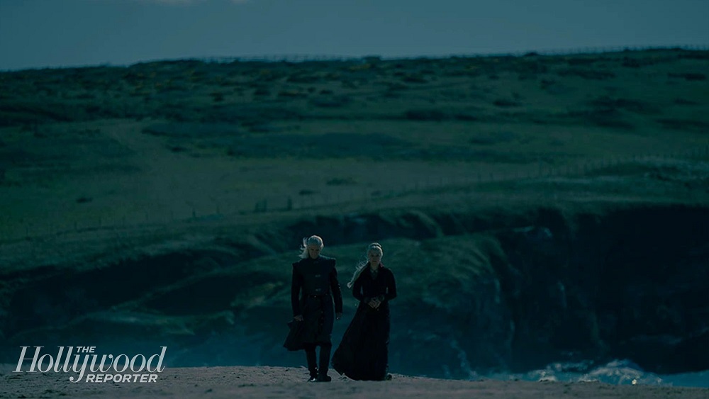 Matt Smith as Prince Daemon Targaryen and Emma D'Arcy as Princess Rhaenyra Targaryen, walking down a dark beach side-by-side on House of the Dragon.