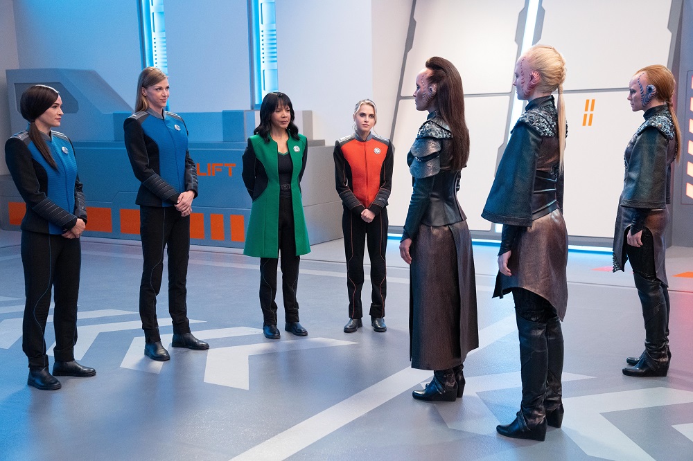 Lt. Cmdr. Talla Keyali, Cmdr. Kelly Grayson, Dr. Claire Finn and Ensign Charly Burke meet the Janisi delegates aboard the Orville in The Orville: New Horizons Season 3 Episode 7 "From Unknown Graves."