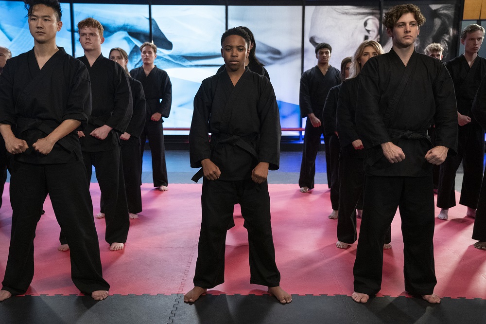 The students of Cobra Kai stand at attention in the dojo.