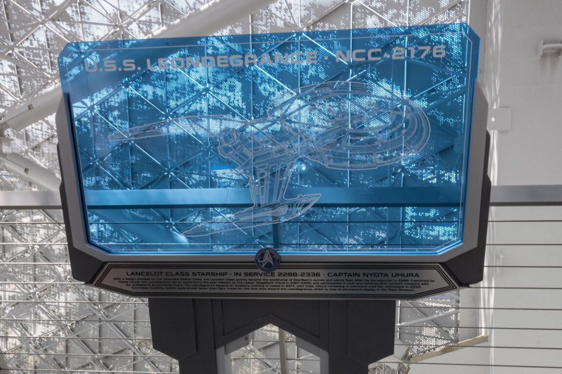 The U.S.S. Leondegrance NCC-2176 plaque, on display at the Starfleet Academy set. It is a sort of blue future-y looking screen with a picture of a ship on it.