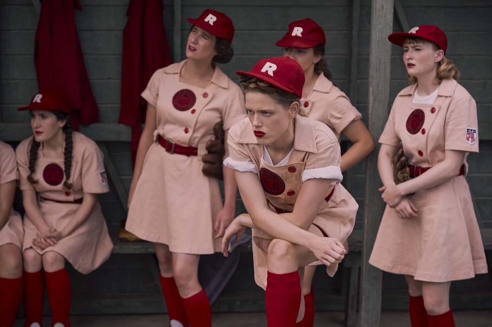 Jess McCready stands with her leg on a bench while wearing a baseball uniform on A League of Their Own Season 1 Episode 7 "Full Count."