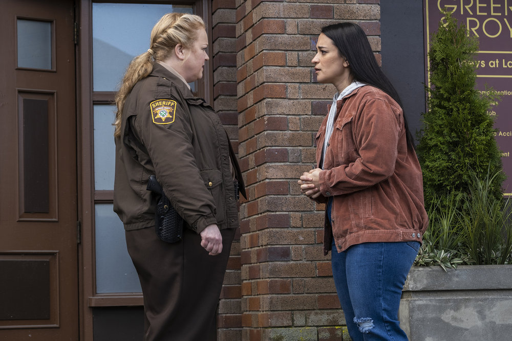 Deputy Liv Baker and Asta Twelvetrees talk in front of the police station in Patience, Colorado on Resident Alien Season 2 Episode 9 "Autopsy."