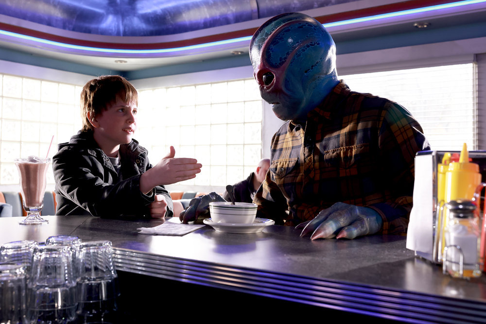 Max chats with Alien Harry at the bar of a diner on Resident Alien Season 2 Episode 11, "The Weight."