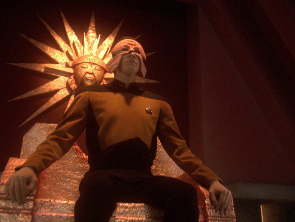 Data sits on a golden throne while something is draped over his face on Star Trek: The Next Generation.