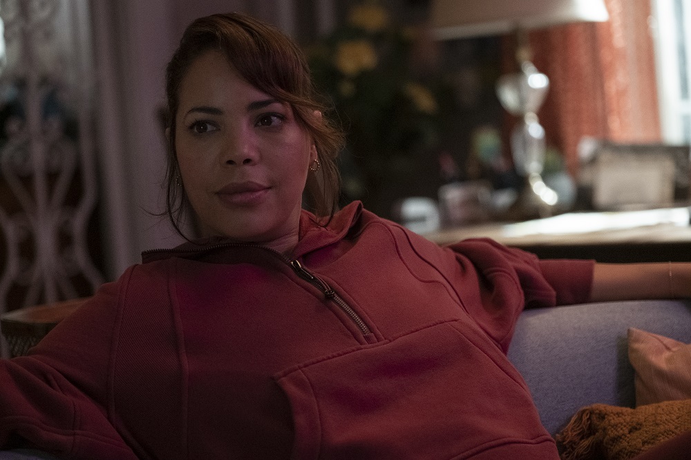 Tammy sits on a couch in a red hoodie in Kevin Can F**k Himself Season 2 Episode 6, "The Machine."