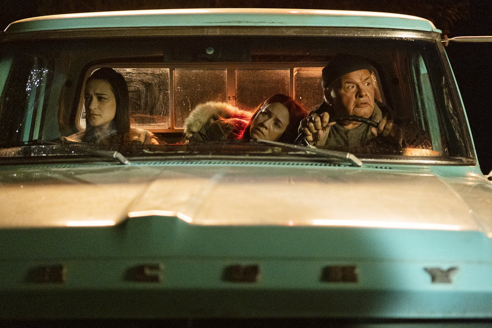 Asta and D'Arcy ride along with Dan in his truck in Resident Alien Season 2 Episode 15, "Best of Enemies."