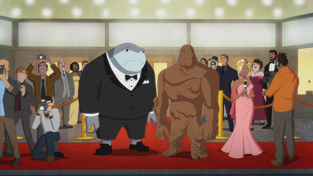 King Shark wears a tuxedo while standing next to a forlorn Clayface at a movie premiere on Harley Quinn Season 3 Episode 10, "The Horse and the Sparrow."