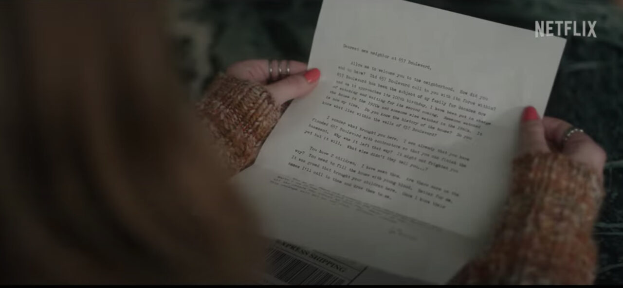 Maria holding the ominous letter sent to them from The Watcher.