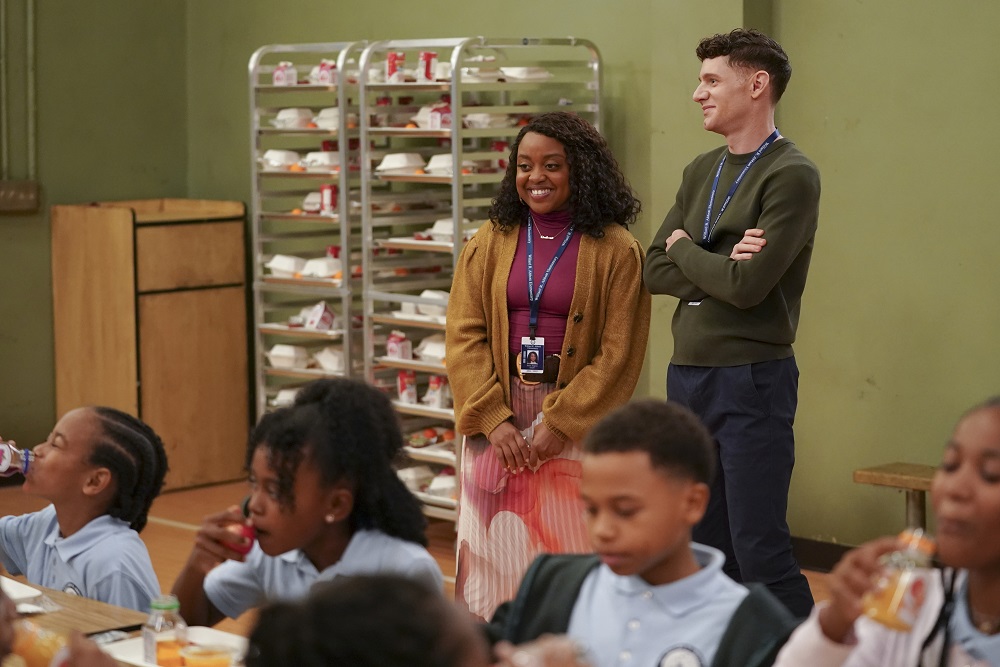 Janine and Jacob stand in the cafeteria while watching students eat in Abbott Elementary Season 2 Episode 5, "Juice."
