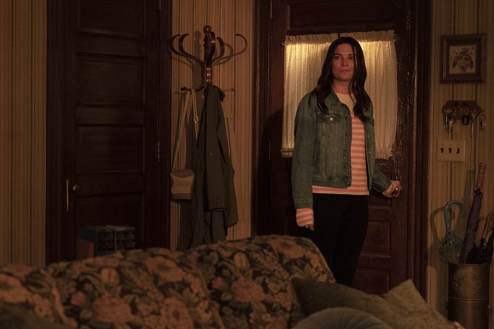 Allison stands in the living room with her hand on the front door knob while looking satisfied in Kevin Can F**k Himself Season 2 Episode 8, "Allison's House."