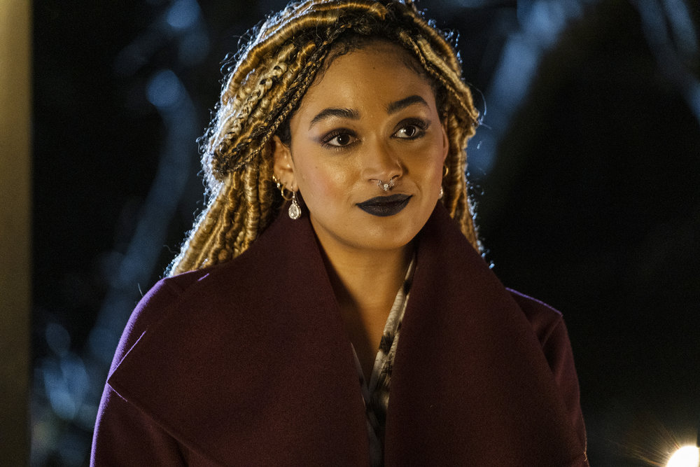 Angela wears a dark burgundy coat while standing outside at night in Reginald the Vampire Season 1 Episode 2, "The Hunger."