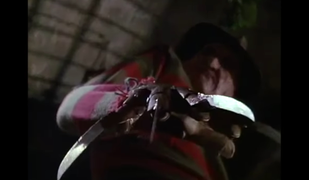 Freddy holds his finger knives toward the camera