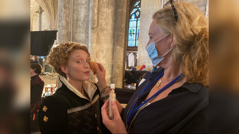 Makeup artist Jacquetta Levon applies makeup to actress Ludivine Sagnier on the set of The Serpent Queen.