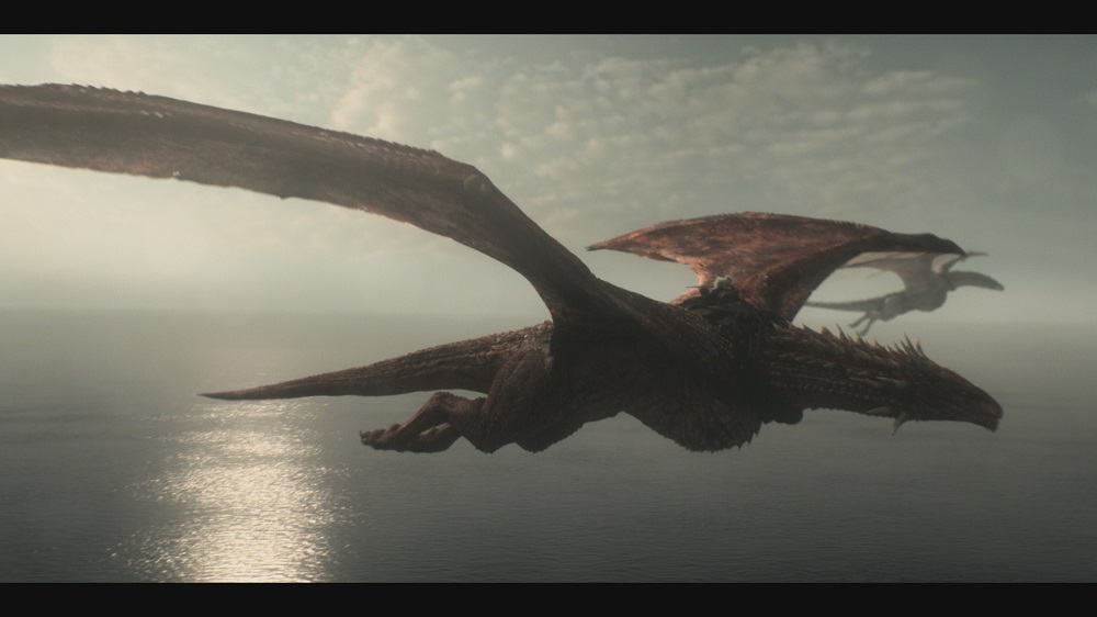 Rhaenys Targaryen sits on the back of her red dragon Meleys while flying over the ocean in House of the Dragon.