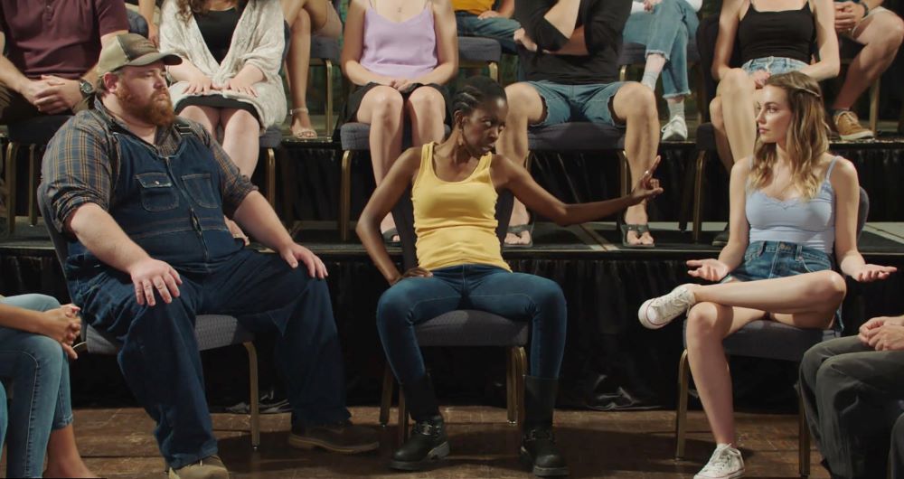 Squirrely Dan, Gail and Katy sit next to each other in a bar while engaged in passionate conversation in Letterkenny Season 11 Episode 1, "Chips."