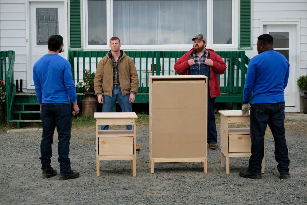 Wayne and Squirrely Dan stand outside while examining wooden cabinets and desks in Letterkenny Season 11 Episode 2, "Okoya."