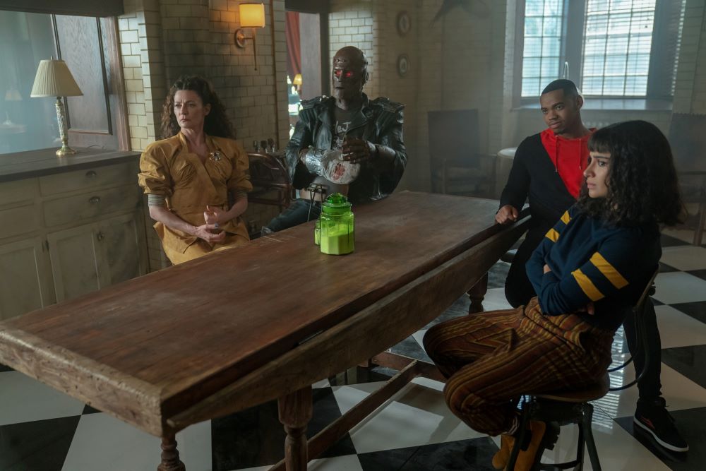 Laura, Cliff, Vic, and Jane sit at their kitchen table in Doom Manor while listening intently in Doom Patrol Season 4 Episode 5, "Youth Patrol."