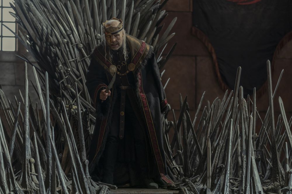 King Viserys stands in front of the Iron Throne while gesturing with a dagger in House of the Dragon Season 1 Episode 8, "The Lord of the Tides."