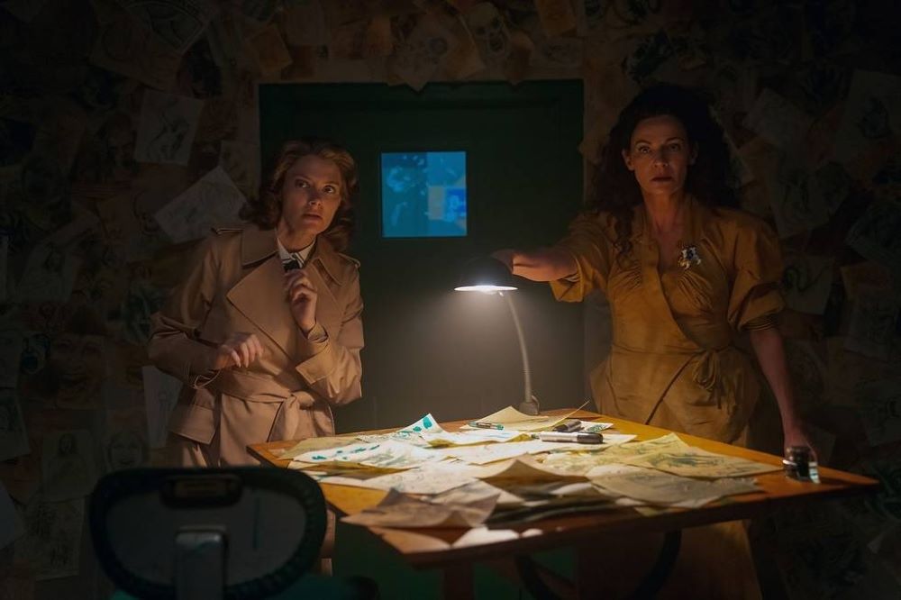 Rita and Laura stand in a dark prison cell while Laura reaches toward a desk lamp in Doom Patrol Season 4 Episode 6, "Hope Patrol."
