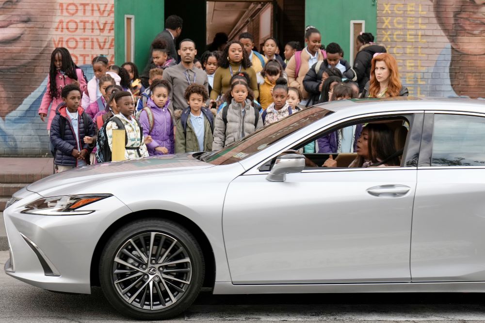 Melissa, Janine and Gregory stand with their students outside the school while watching Ava drive by in her car in Abbott Elementary Season 2 Episode 15, "Fire."