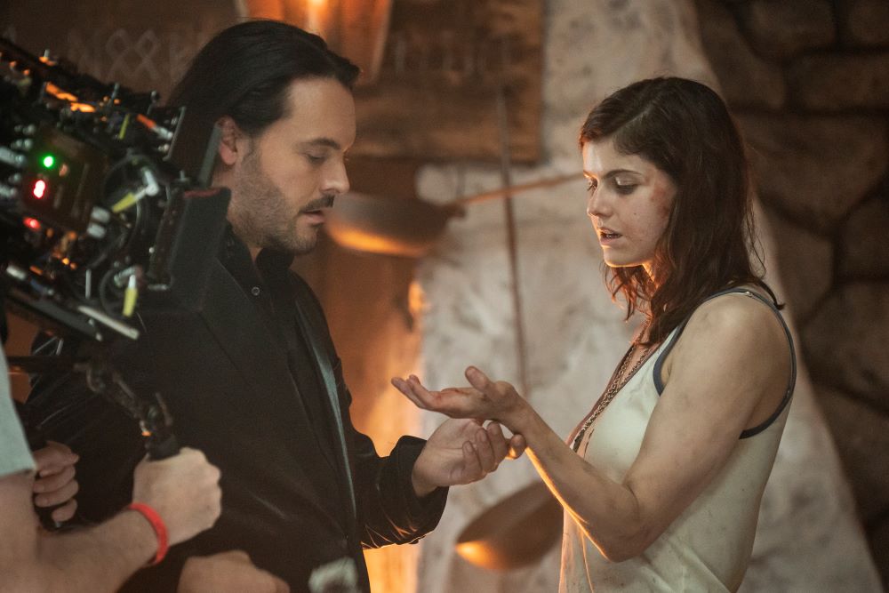 Behind the scenes photo from Mayfair Witches Season 1 Episode 8, "What Rough Beast," featuring actors Jack Huston and Alexandra Daddario filming a scene on the set of Suzanne Mayfair's cottage.