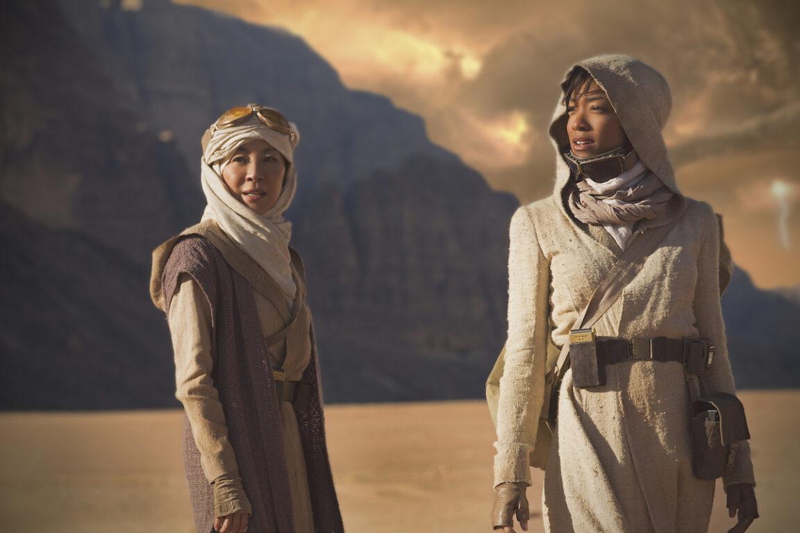 Michelle Yeoh as Captain Philippa Georgiou; Sonequa Martin-Green as First Officer Michael Burnham on Star Trek: Discovery's pilot. They are in a desert and wearing appropriate attire.