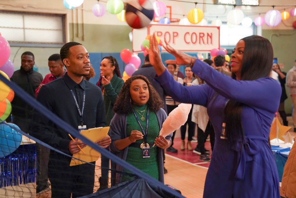 Gregory and Janine watch Ava play with a beach ball during a party in Abbott Elementary Season 2 Episode 19, "Festival."