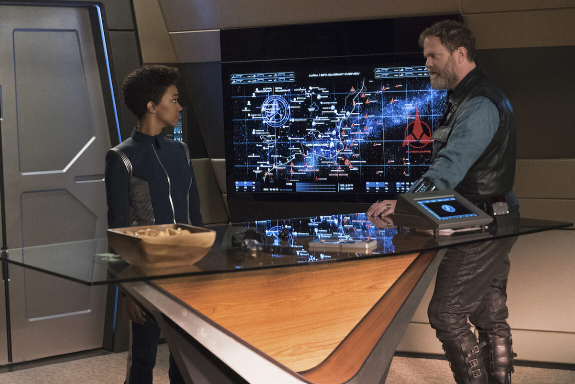 Sonequa Martin-Green as First Officer Michael Burnham; Rainn Wilson as Harry Mudd of the CBS All Access series STAR TREK: DISCOVERY. They are standing in front of a starmap.