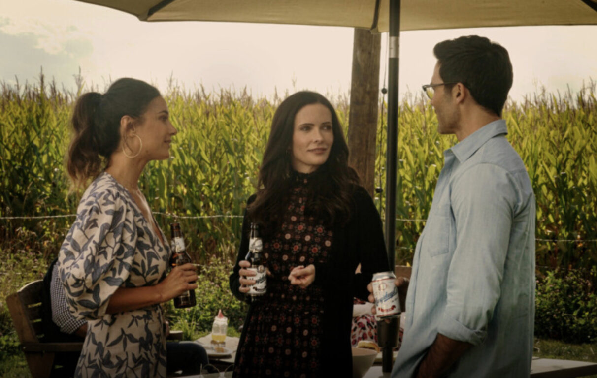 Lana, Lois and Clark, standing, holding drinks and talking. 