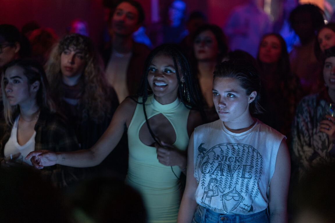 Celeste O’Connor and Florence Pugh stand in a crowd listening to music in A Good Person. 