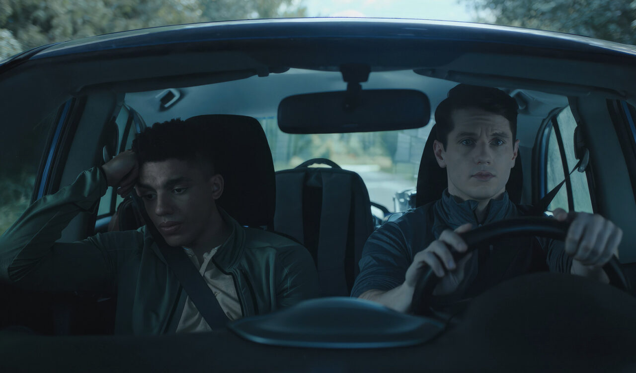 Bernard driving and Tim on the passengers' side in a car