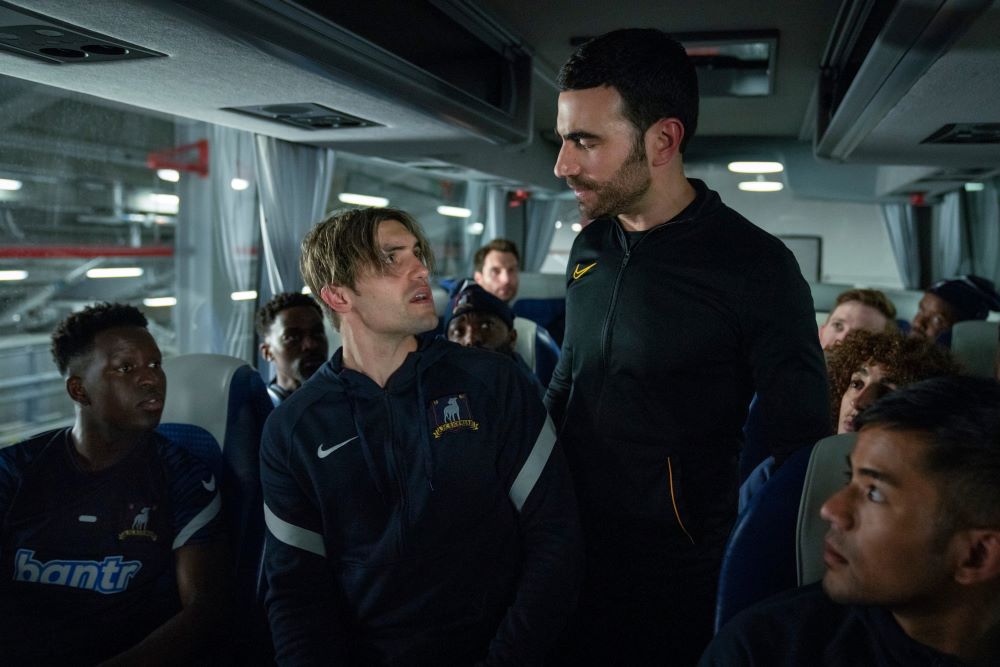 Jamie looks up at Roy while sitting on the bus in Ted Lasso Season 3 Episode 6, "Sunflowers."