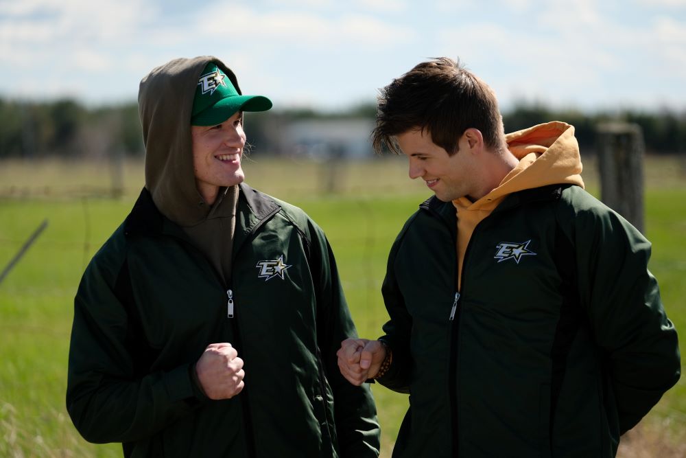 Reilly and Jonesy pound their fists together and smile while standing outside in Letterkenny Season 11 Episode 7, "May 2-4."