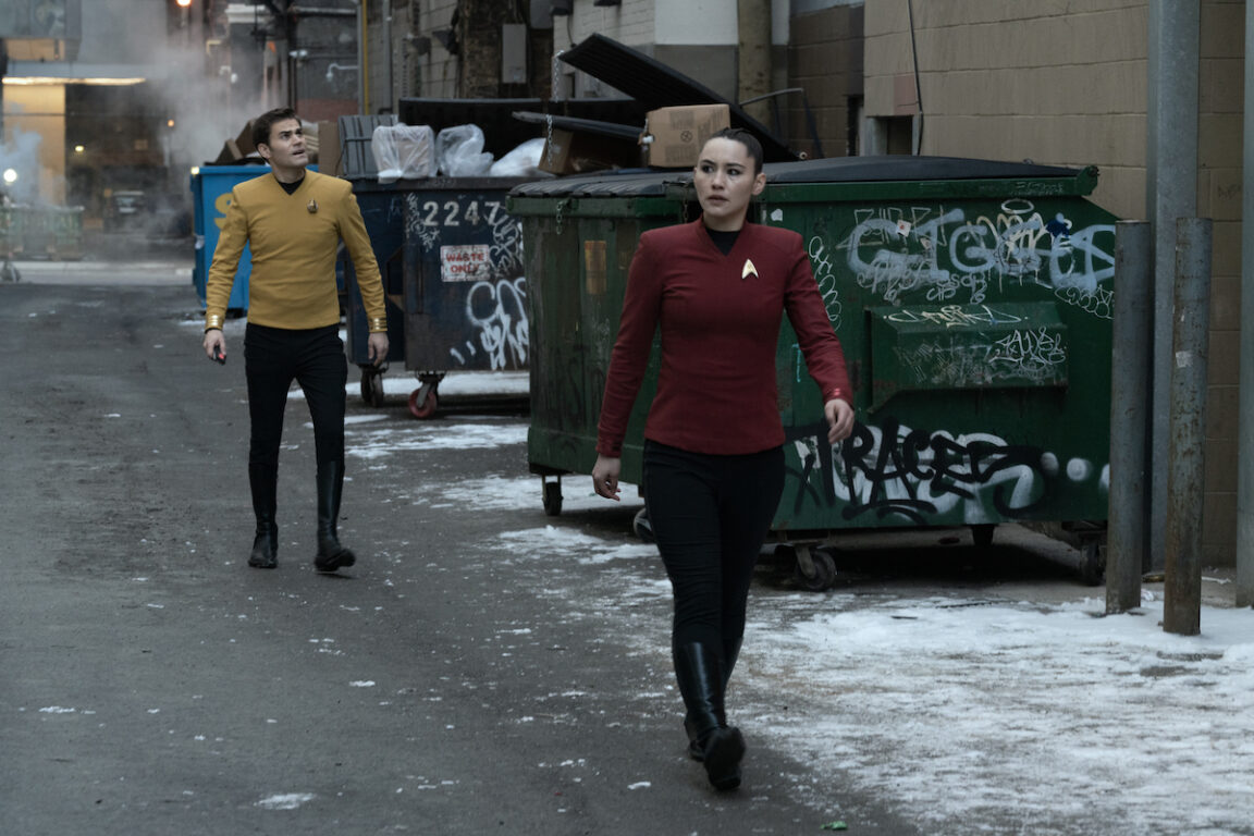 Christina Chong as La’an and Paul Wesley as Kirk in episode 203 “Tomorrow and Tomorrow and Tomorrow." They are both dressed in Starfleet uniforms but walking through a 21st century Toronto alleyway.