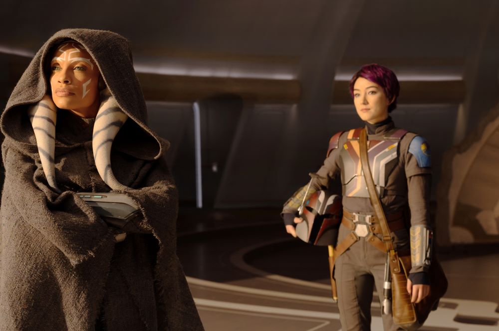 Ahsoka Tano and Sabine Wren stand beside each other while looking focused.