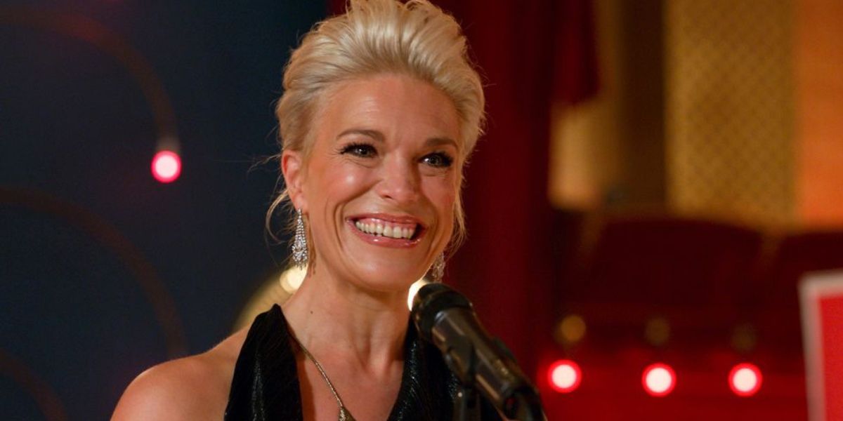 Hannah Waddingham on 'Ted Lasso' standing in front of a mic, smiling.