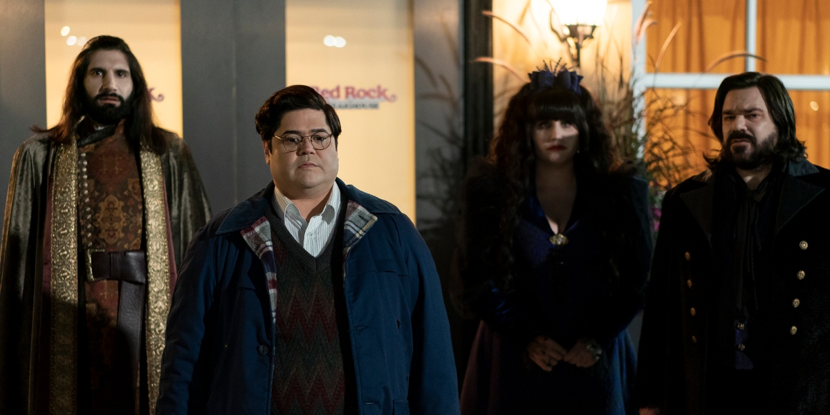 Nandor, Guillermo, Nadja and Laszlo leave a restaurant while Guillermo holds a lot of to-go bags in What We Do in the Shadows Season 5 Episode 1, "The Mall."