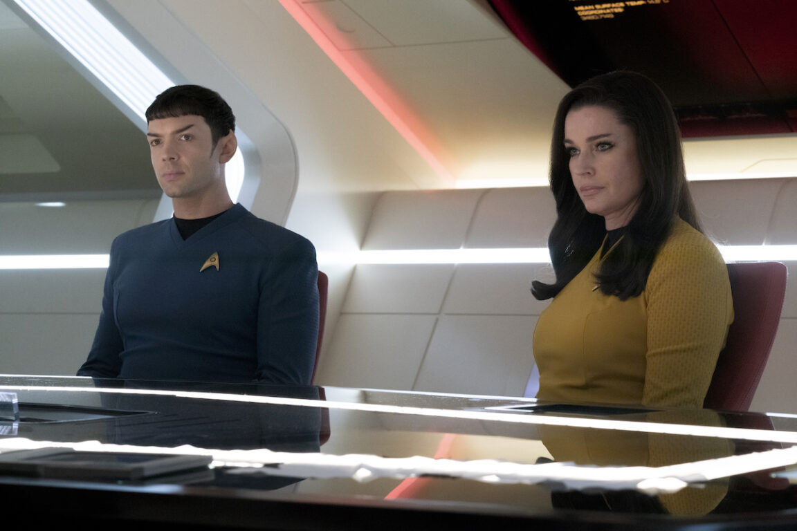 Ethan Peck as Spock and Rebecca Romijn as Una in Star Trek: Strange New Worlds' season 2 finale, "Hegemony." They're both sitting at the Ready Room table.